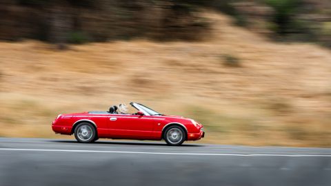 Foto de un convertible rojo a alta velocidad por la carretera