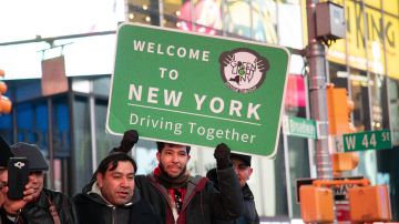 Foto de varios inmigrantes en New York con un cartel