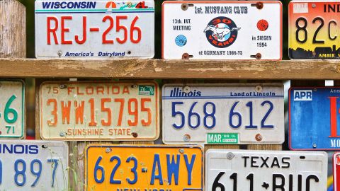 Foto de varias placas de matrícula apiladas en una pared