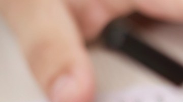 Foto de las manos de una persona presentando un examen escrito