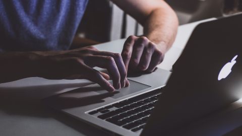 Foto de un hombre escribiendo en una laptop