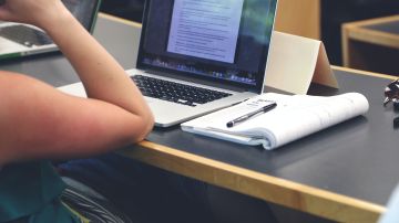 Foto de una persona estudiando frente a una computadora