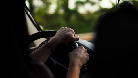 Foto de las manos de una persona sobre el volante de un auto