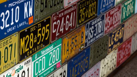 Foto de varias placas de matrícula apiladas en una pared