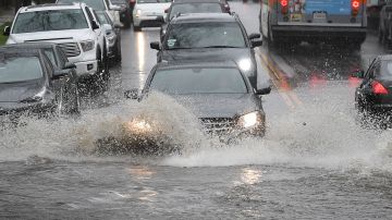 Cars drive through a flooded street after a storm dumped heavy rain on Los Angeles, California on February 2, 2019, - The city is enduring three back-to-back storms with heavy rain that is causing havoc in the normally dry climate of Southern California. (Photo by Mark RALSTON / AFP) (Photo credit should read MARK RALSTON/AFP via Getty Images)