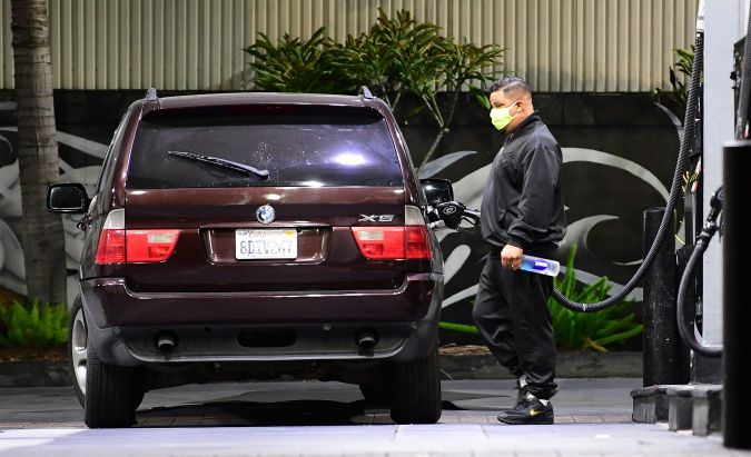 A man wears a facemask while filling gas at a petrol station in Los Angeles, California on April 21, 2020, a day after oil prices dropped to below zero as the oil industry suffers steep falls in benchmark crudes due to the ongoing global coronavirus pandemic. - US oil prices surged on April 22 after falling below zero for the first time at the start of the week as markets drown in crude due to a virus-triggered collapse in demand. (Photo by Frederic J. BROWN / AFP) (Photo by FREDERIC J. BROWN/AFP via Getty Images)