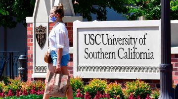 A woman walks past a sign at the University of Southern California (USC) in Los Angeles, California on August 25, 2020 where coronavirus cases have seen an alarming increase with more than 100 students in quarantine from cases originating in off-campus housing. (Photo by Frederic J. BROWN / AFP) (Photo by FREDERIC J. BROWN/AFP via Getty Images)