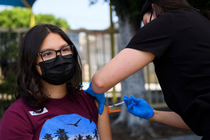 Audrey Romero, 16, receives a first dose of the Pfizer Covid-19 vaccine at a mobile vaccination clinic at the Weingart East Los Angeles YMCA on May 14, 2021 in Los Angeles, California. - The campaign to immunize America's 17 million adolescents aged 12-to-15 kicked off in full force on May 13. The YMCA of Metropolitan Los Angeles is working to overcome vaccine hesitancy and expand access in high risk communities with community vaccine clinics in the area. (Photo by Patrick T. FALLON / AFP) (Photo by PATRICK T. FALLON/AFP via Getty Images)