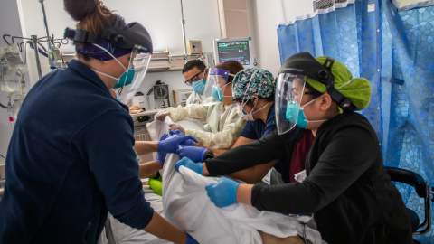 Health care workers attend to a patient with Covid-19 as they prepare to turn the 46 year old unvaccinated patient from his stomach onto his back at the Cardiovascular Intensive Care Unit at Providence Cedars-Sinai Tarzana Medical Center in Tarzana, California on September 2, 2021. - According to Dr. Yadegar at the hospital, the number of covid patients are significantly less than they were in winter, but from a psychological standpoint it's much more difficult because most of the patients in the ICU on respirators are unvaccinated, younger and healthier 30 and 40 year olds without comorbidities. Vaccinated patients at the hospital are typically older, but the Covid-19 effects are much milder compared to the unvaccinated patients that have more severe symptoms. (Photo by Apu GOMES / AFP) (Photo by APU GOMES/AFP via Getty Images)
