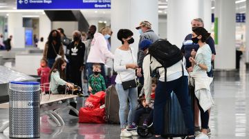 Travellers collect their luggage at the airport in Los Angeles, California on November 23, 2021, where up to two million people are expected to travel over the Thanksgiving Day holidays. (Photo by Frederic J. BROWN / AFP) (Photo by FREDERIC J. BROWN/AFP via Getty Images)
