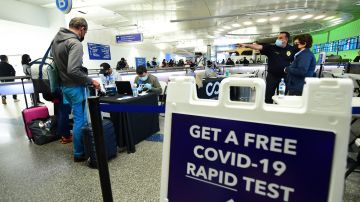 A traveller provides information ahead of a free Covid-19 test in the international terminal at Los Angeles International Airport on December 3, 2021, where a rapid Covid-19 testing site opened. - The free tests are being offered to anyone arriving in Los Angeles who may feel sick of from any country reporting cases of the new omicron variant. (Photo by Frederic J. BROWN / AFP) (Photo by FREDERIC J. BROWN/AFP via Getty Images)