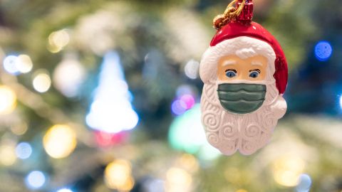 A photograph taken on December 17, 2021 shows a Christmas decoration depicting a Santa Claus with a protective facemask hanged on a Chrsitmas tree, in Paris. (Photo by JOEL SAGET / AFP) (Photo by JOEL SAGET/AFP via Getty Images)