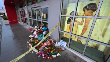 Flowers and baloons are left along a sign reading "Release the Footage Moore" at a makeshift memorial for the teenage girl who was killed by a police stray bullet at a Burlington coat factory in North Hollywood, California, December 27, 2021. - Bodycam footage of the "chaotic" police shooting of a teenager in a California department store was released Monday, as critics claimed officers were all-too-ready to open fire. Fourteen-year-old Valentina Orellana-Peralta was trying on clothes in a changing room when a stray bullet came through the wall and hit her, killing her instantly on December 23. (Photo by Robyn Beck / AFP) (Photo by ROBYN BECK/AFP via Getty Images)