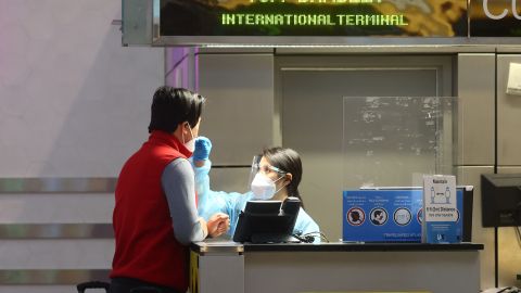 LOS ANGELES, CALIFORNIA - DECEMBER 01: A person is tested for COVID-19 inside the Tom Bradley International Terminal at Los Angeles International Airport (LAX) on December 01, 2021 in Los Angeles, California. The Biden administration is planning to announce tighter restrictions for travelers flying into the United States, including requiring a negative test for COVID-19 one day ahead of travel, in response to the new Omicron variant. (Photo by Mario Tama/Getty Images)