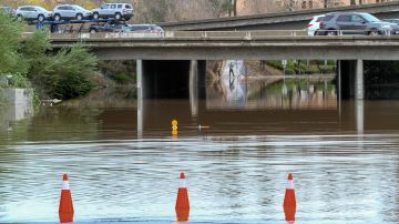 Cars drive over a road flooded by the San Diego River after heavy rains in San Diego, California on January 7, 2016. The first major El Nino storm of the season battered southern California this week, bringing heavy rain to the drought-stricken region and causing flooding and mudslides in some areas. Several El Nino storms are expected to hit California in the coming weeks, but experts warn that the rainfall will not be enough to help the region recover from a historic drought. AFP PHOTO/ BILL WECHTER / AFP / Bill Wechter (Photo credit should read BILL WECHTER/AFP via Getty Images)