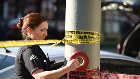A female police officer uses police tape to cordon off an area outside a Jack in the Box restaurant in Hollywood, California, January 31, 2017, after police shot and killed a knife-wielding suspect inside the restaurant following a series of stabbing in the vicinity. Authorities said a person described only as a male was pronounced dead at the scene, while two of the male stabbing victims have critical injuries and a third was in fair condition. / AFP / Robyn Beck (Photo credit should read ROBYN BECK/AFP via Getty Images)