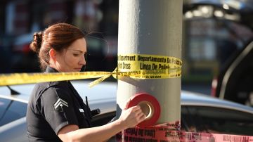 A female police officer uses police tape to cordon off an area outside a Jack in the Box restaurant in Hollywood, California, January 31, 2017, after police shot and killed a knife-wielding suspect inside the restaurant following a series of stabbing in the vicinity. Authorities said a person described only as a male was pronounced dead at the scene, while two of the male stabbing victims have critical injuries and a third was in fair condition. / AFP / Robyn Beck (Photo credit should read ROBYN BECK/AFP via Getty Images)
