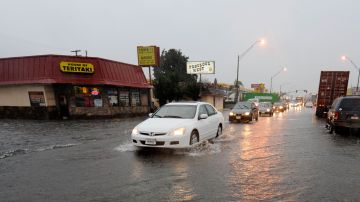 LONG BEACH, CA - JANUARY 20: Commercial trucks and cars make their way through a flooded intersection during a heavy downpour on January 20, 2010 in Long Beach, California. Fearing the storms could touch off mudslides, officials evacuated nearly 800 homes in the foothills near Los Angeles today. (Photo by Kevork Djansezian/Getty Images)