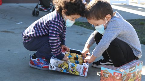 Los hermanitos Ismael y Ethaniel Granados intentan abrir sus regalos.