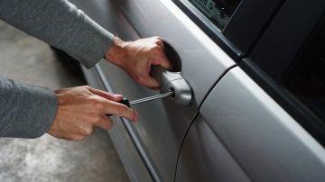 Foto de las manos de una persona que intenta abrir un auto