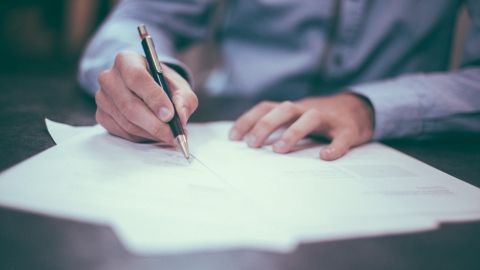 Foto de un hombre firmando documentos