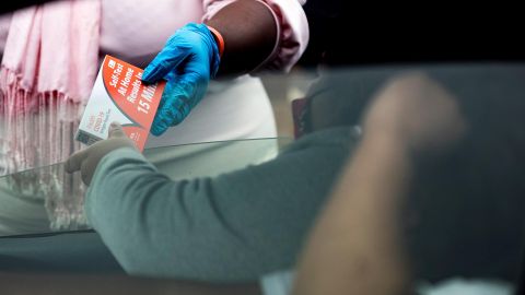 Los Angeles (United States), 07/01/2022.- A woman hands IHeart Covid-19 self at home antigen tests for students at the Johnnie L. Cochran Jr. Middle School in Los Angeles, California, USA, 07 January 2022. Students will go back to school next week. (Estados Unidos) EFE/EPA/ETIENNE LAURENT