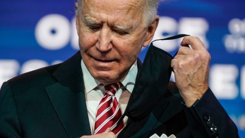 WILMINGTON, DE - DECEMBER 23: President-elect Joe Biden removes his mask before announcing Miguel Cardona as his nominee for Education Secretary at the Queen theatre on December 23, 2020 in Wilmington, Delaware. Cardona, the Connecticut Education Commissioner, will face the urgent task of planning to reopen schools safely during the COVID-19 pandemic. (Photo by Joshua Roberts/Getty Images)