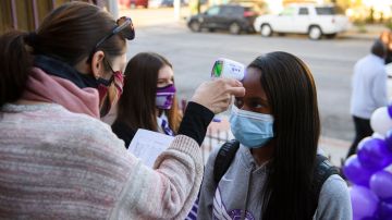 A student receives a temperature check before class as they return to in-person learning at St. Anthony Catholic High School during the Covid-19 pandemic, on March 24, 2021 in Long Beach, California. - The school of 445 students implemented a hybrid learning model, with approximately 60 percent of students returning to in an in-person classroom learning environment with Covid-19 safety measures including face masks, social distancing, plexiglass barriers around desks, outdoor spaces, and schedule changes. (Photo by Patrick T. FALLON / AFP) (Photo by PATRICK T. FALLON/AFP via Getty Images)