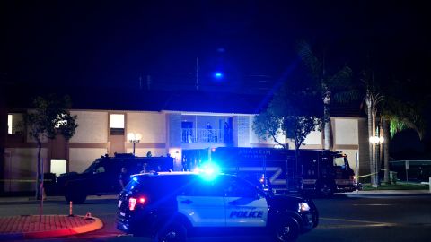 Police officers stand outside an office building were multiple people were killed in a shooting in Orange, California on March 31, 2021. - Authorities said that four people, including a child, were killed in a shooting and two others had been transported to local hospitals. The suspect is in custody and was also taken to the hospital. When officers arrived, the shots were still being fired and the police found several victims, said the police, who indicated that the situation had resulted in an officer-involved shooting. (Photo by Patrick T. FALLON / AFP) (Photo by PATRICK T. FALLON/AFP via Getty Images)