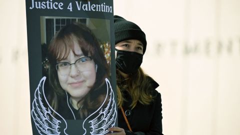 A protestor holds signs calling for justice for 14-year old Valentina Orellana-Peralta, who was killed by a stray police bullet last week while shopping at a clothing store, during a press conference outside Los Angeles Police Department headquarters in Los Angeles, California, December 28, 2021. (Photo by Robyn Beck / AFP) (Photo by ROBYN BECK/AFP via Getty Images)