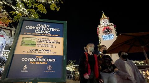 People walk past a sign for a Covid-19 testing center at the Farmers Market at Third St and Fairfax Blvd in Los Angeles, California on January 5, 2022. - The United States reported more than one million new Covid-19 cases on January 4 after the long New Year's weekend, according to data from Johns Hopkins University, as the Omicron variant spread at a blistering pace. (Photo by VALERIE MACON / AFP) (Photo by VALERIE MACON/AFP via Getty Images)