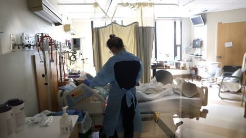 SEATTLE, WA - JANUARY 21: (EDITORIAL USE ONLY) Nurse Elisa Gilbert checks on a patient in the acute care COVID-19 unit at the Harborview Medical Center on January 21, 2022 in Seattle, Washington. The highly transmissible omicron variant is putting a significant strain on health systems nationally resulting in staffing shortages and changes in capacity strategies. (Photo by Karen Ducey/Getty Images)