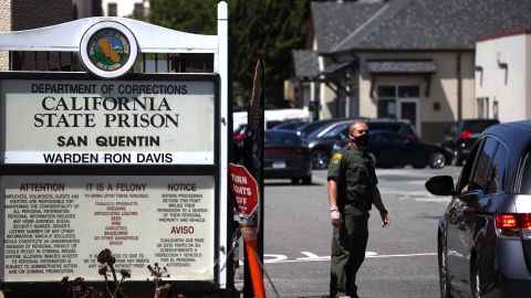 SAN QUENTIN, CALIFORNIA - JUNE 29: A California Department of Corrections and Rehabilitation (CDCR) officer wears a protective mask as he stands guard at the front gate of San Quentin State Prison on June 29, 2020 in San Quentin, California. San Quentin State Prison is continuing to experience an outbreak of coronavirus COVID-19 cases with over 1,000 confirmed cases amongst the staff and inmate population. San Quentin had zero cases of COVID-19 prior to a May 30th transfer of 121 inmates from a Southern California facility that had hundreds of active cases 13 COVID-19-related deaths. (Photo by Justin Sullivan/Getty Images)