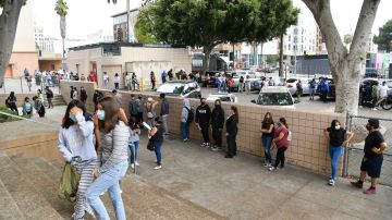 HOLLYWOOD, CALIFORNIA - AUGUST 13: Students wait in line to pick up school resources at Hollywood High School on August 13, 2020 in Hollywood, California. With over 734,000 enrolled students, the Los Angeles Unified School District is the largest public school system in California and the 2nd largest public school district in the United States. With the advent of COVID-19, blended learning, or combined online and classroom learning, will become the norm for the coming school year. (Photo by Rodin Eckenroth/Getty Images)