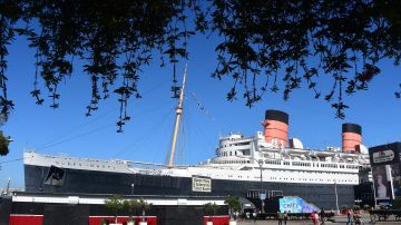 People enjoy the chance for a day's free admission to celebrate the 80th anniversary of the Queen Mary on September 26, 2014 in Long Beach, California. Known as the "Grey Ghost' during the Second World War when the ship transported Allied soldiers, the Queen Mary was a favourite among British royalty and Hollywood celebrities during the postwar years and remained a top ocean liner up until the 1960's when air travel became more popular than sailing, and in 1967 the ageing vessel was retired to Long Beach and turned into a hotel and an events venue. The Queen Mary was launched on this day in 1934 on Scotland's River Clyde and took her maiden voyage on May 27, 1936. AFP PHOTO / Frederic J. BROWN (Photo credit should read FREDERIC J. BROWN/AFP via Getty Images)