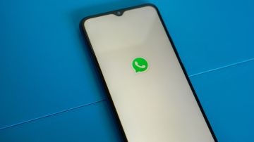 Foto de un teléfono mostrando en la pantalla el inicio de WhatsApp