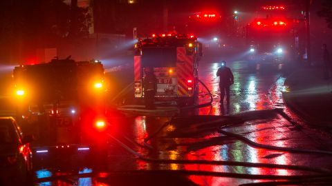 Firefighters work to save homes from the Saddleridge Fire in the Porter Ranch section of Los Angeles, California, on October 11, 2019. - The fire broke out late October 10 and has scorched some 4,600 acres (1,816 hectares), and forced mandatory evacuation orders for 12,700 homes. (Photo by DAVID MCNEW / AFP) (Photo by DAVID MCNEW/AFP via Getty Images)