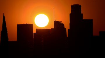 The sun sets behind highrise buildings in downtown Los Angeles, California on September 30, 2020. - A heat advisory is in effect for southern California as temperatures hit triple-digits this week with potential for stress on the power grid causing power outages or rolling blackouts. (Photo by Frederic J. BROWN / AFP) (Photo by FREDERIC J. BROWN/AFP via Getty Images)