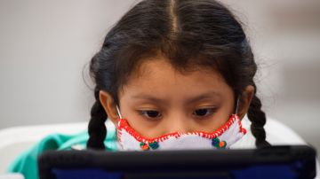 A child attends an online class at a learning hub inside the Crenshaw Family YMCA during the Covid-19 pandemic on February 17, 2021 in Los Angeles, California. - While many area schools remain closed for in-person classes, the learning hub program provides structured distance education resources including free WiFi, electricity, staff support, academic tutoring, and recreation activities to provide a safe environment to support low income and minority communities. (Photo by Patrick T. FALLON / AFP) (Photo by PATRICK T. FALLON/AFP via Getty Images)