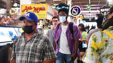 Masked and unmasked people make their way through Grand Central Market in Los Angeles, California on June 29, 2021 as World Health Organization (WHO) urges fully vaccinated people to continue wearing masks with the rapid spread of the Delta variant. - Officials are issuing new mask guidance as Covid-19 cases are spiking in parts of the US, especially in areas with low vaccination rates due to the more contagious Delta variant. (Photo by Frederic J. BROWN / AFP) (Photo by FREDERIC J. BROWN/AFP via Getty Images)