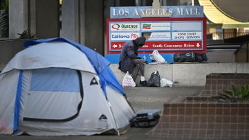 A man sits beside a tent on a street in downtown Los Angeles, California December 8, 2021. - The 2020 Greater Los Angeles Homeless Count released by the Los Angeles Homeless Services Authority in June 2020 revealed that 66,436 people in Los Angeles County are homeless, a rise of a 12.7% from the previous year, while the city of Los Angeles saw a 16.1% rise in the unhoused population to a total of 41,290 persons. (Photo by Robyn Beck / AFP) (Photo by ROBYN BECK/AFP via Getty Images)