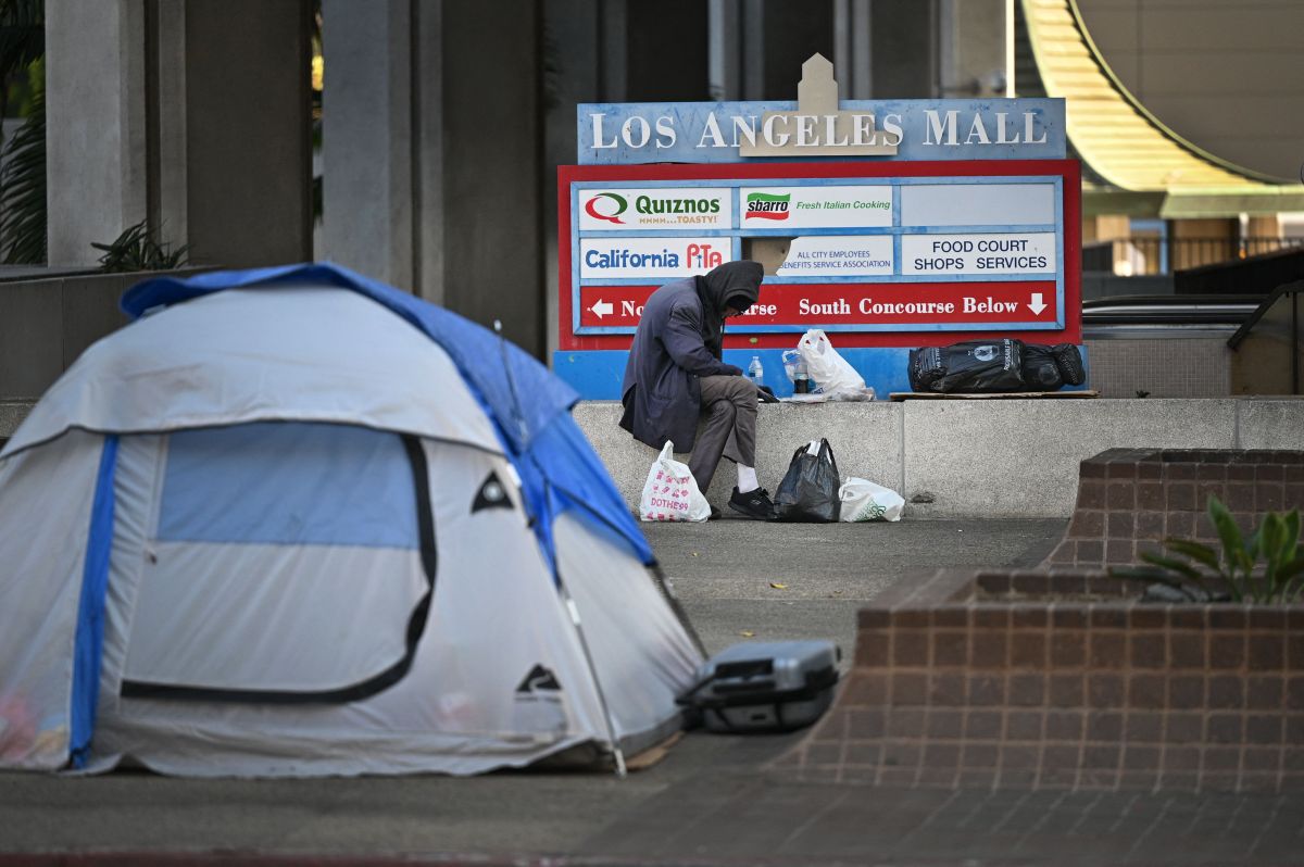 A man sits beside a tent on a street in downtown Los Angeles, California December 8, 2021. - The 2020 Greater Los Angeles Homeless Count released by the Los Angeles Homeless Services Authority in June 2020 revealed that 66,436 people in Los Angeles County are homeless, a rise of a 12.7% from the previous year, while the city of Los Angeles saw a 16.1% rise in the unhoused population to a total of 41,290 persons.  (Photo by Robyn Beck/AFP) (Photo by ROBYN BECK/AFP via Getty Images)