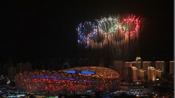 Fuegos artificiales con los aros olímpicos fuera del Estadio Nacional de Beijing.