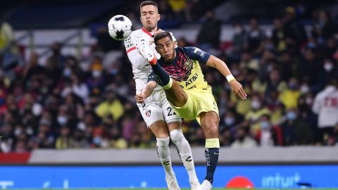 Sebastián Cáceres disputando un balón frente a Franco Troyansky del Atlas.