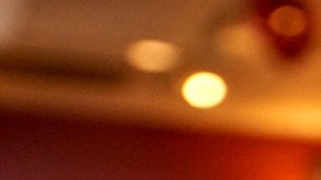 Image de un vaso de Starbucks y de una barista fuera de foco en el fondo