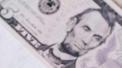 Foto de varios dólares con la palabra "taxes" sobre ellos