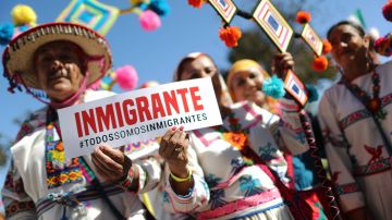 LOS ANGELES, CA - SEPTEMBER 16: Revelers pose with a sign reading 'We Are All Immigrants' in Spanish during the 72nd annual East LA Mexican Independence Day Parade on September 16, 2018 in Los Angeles, California. 11.6 million immigrants from Mexico lived in the U.S. in 2016, making Mexico the top country of origin of U.S. immigrants, according to the Pew Research Center. (Photo by Mario Tama/Getty Images)