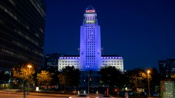 The Los Angeles City Hall is lit in purple and gold as part of the "Forward Into Light" initiative to commemorate the 100th anniversary of the 19th Amendment and women's constitutional right to vote, in Los Angeles on August 26, 2020. - Buildings and landmarks across the country will light up in purple and gold on August 26, 2020 as part of the Commissions nationwide Forward Into Light Campaign, named in honor of the historic suffrage slogan, "Forward through the Darkness, Forward into Light." (Photo by VALERIE MACON / AFP) (Photo by VALERIE MACON/AFP via Getty Images)