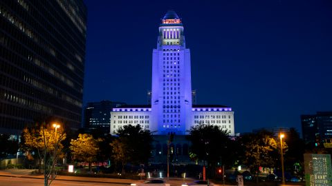 The Los Angeles City Hall is lit in purple and gold as part of the "Forward Into Light" initiative to commemorate the 100th anniversary of the 19th Amendment and women's constitutional right to vote, in Los Angeles on August 26, 2020. - Buildings and landmarks across the country will light up in purple and gold on August 26, 2020 as part of the Commissions nationwide Forward Into Light Campaign, named in honor of the historic suffrage slogan, "Forward through the Darkness, Forward into Light." (Photo by VALERIE MACON / AFP) (Photo by VALERIE MACON/AFP via Getty Images)