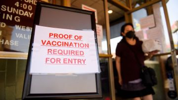 A sign stating proof of a Covid-19 vaccination is required is displayed outside of Langer's Deli in Los Angeles, California on August 7, 2021. - The restaurant announced that proof of vaccination would be required to dine indoors at the restaurant as Covid-19 variant causes surge in the Los Angeles area. (Photo by Patrick T. FALLON / AFP) (Photo by PATRICK T. FALLON/AFP via Getty Images)
